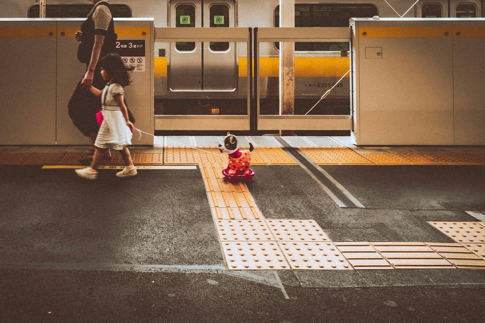 Parent and child walking along a train platform in Japan