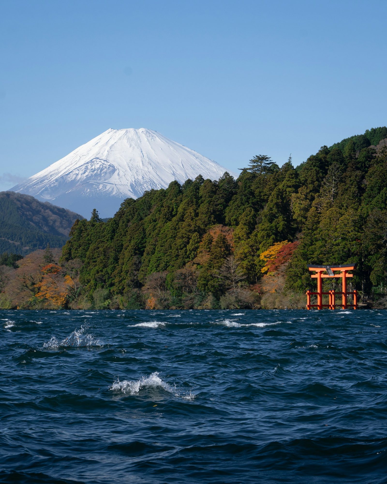 Mount Fuji, Lake Ashi and the red torii gate of Hakone Shrine seen from the water