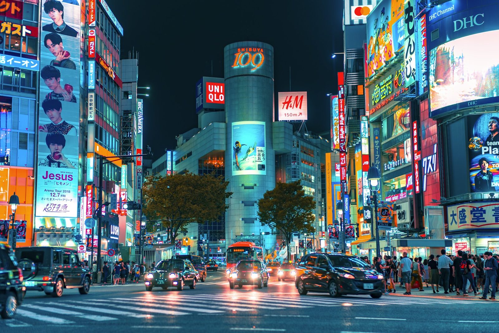 Neon-lit street crossing in Shibuya, Tokyo at night