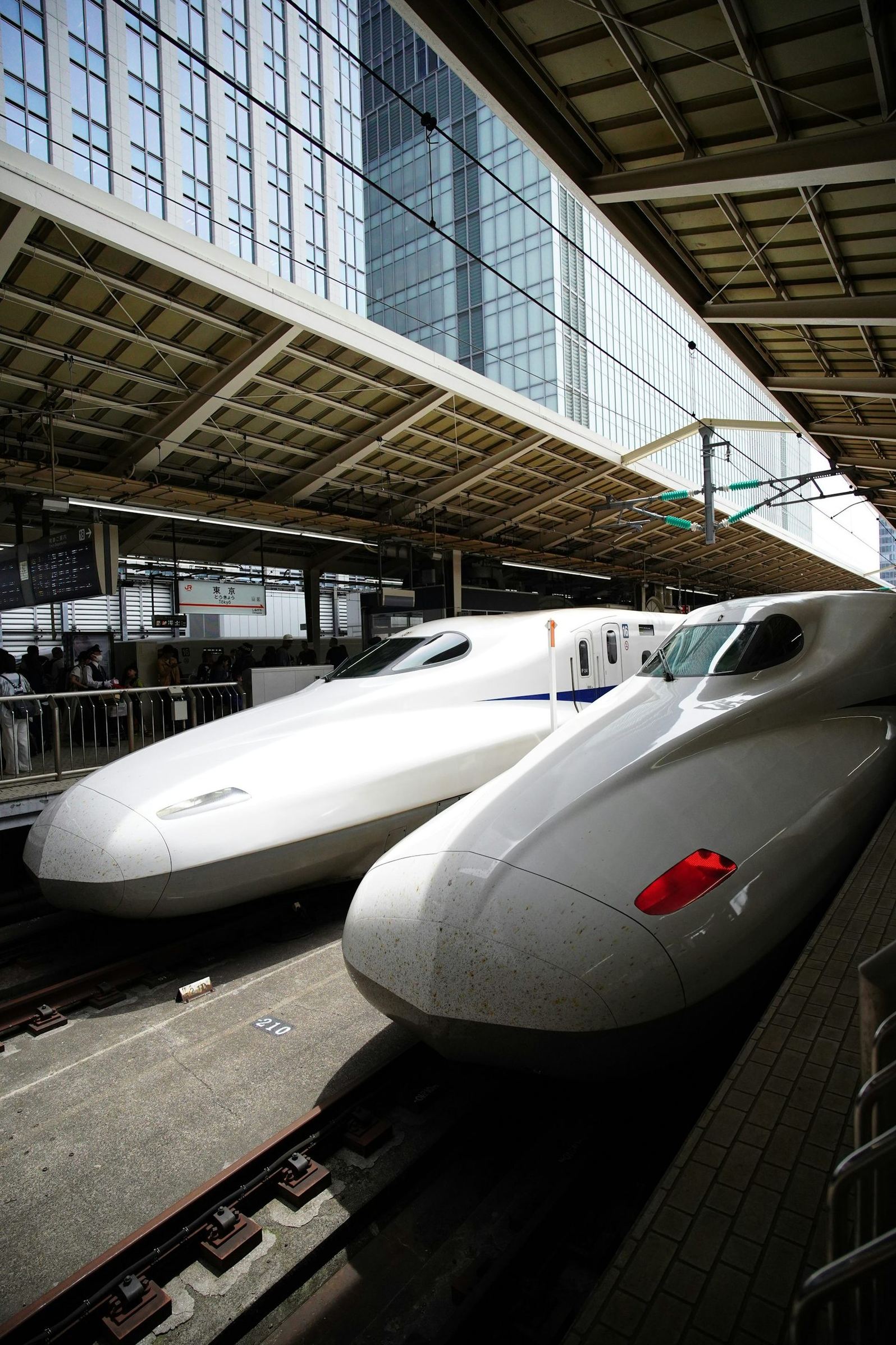 Two white Shinkansen bullet trains lined up at a Japanese station platform