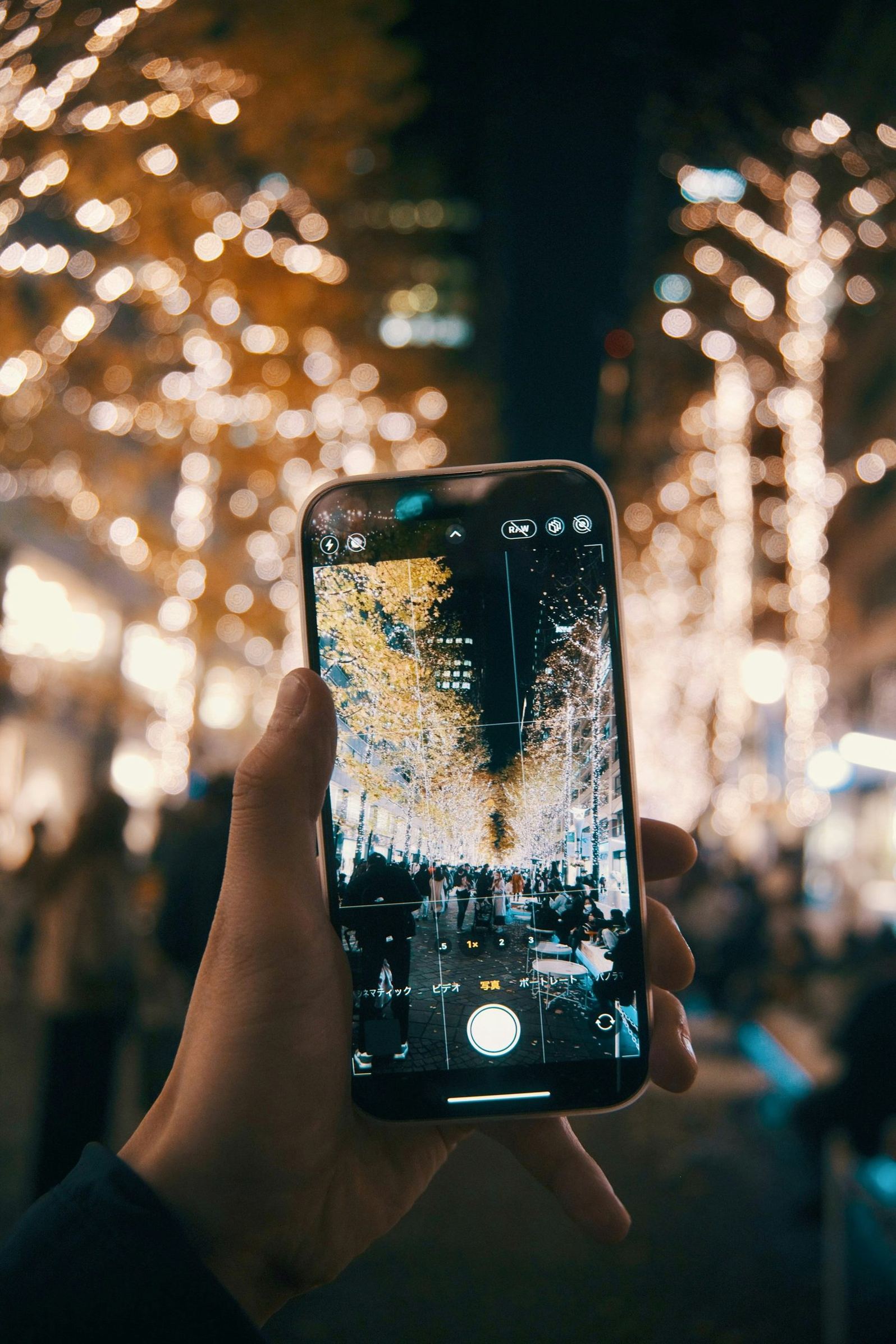 Traveler taking a photo with a smartphone on an illuminated Tokyo street