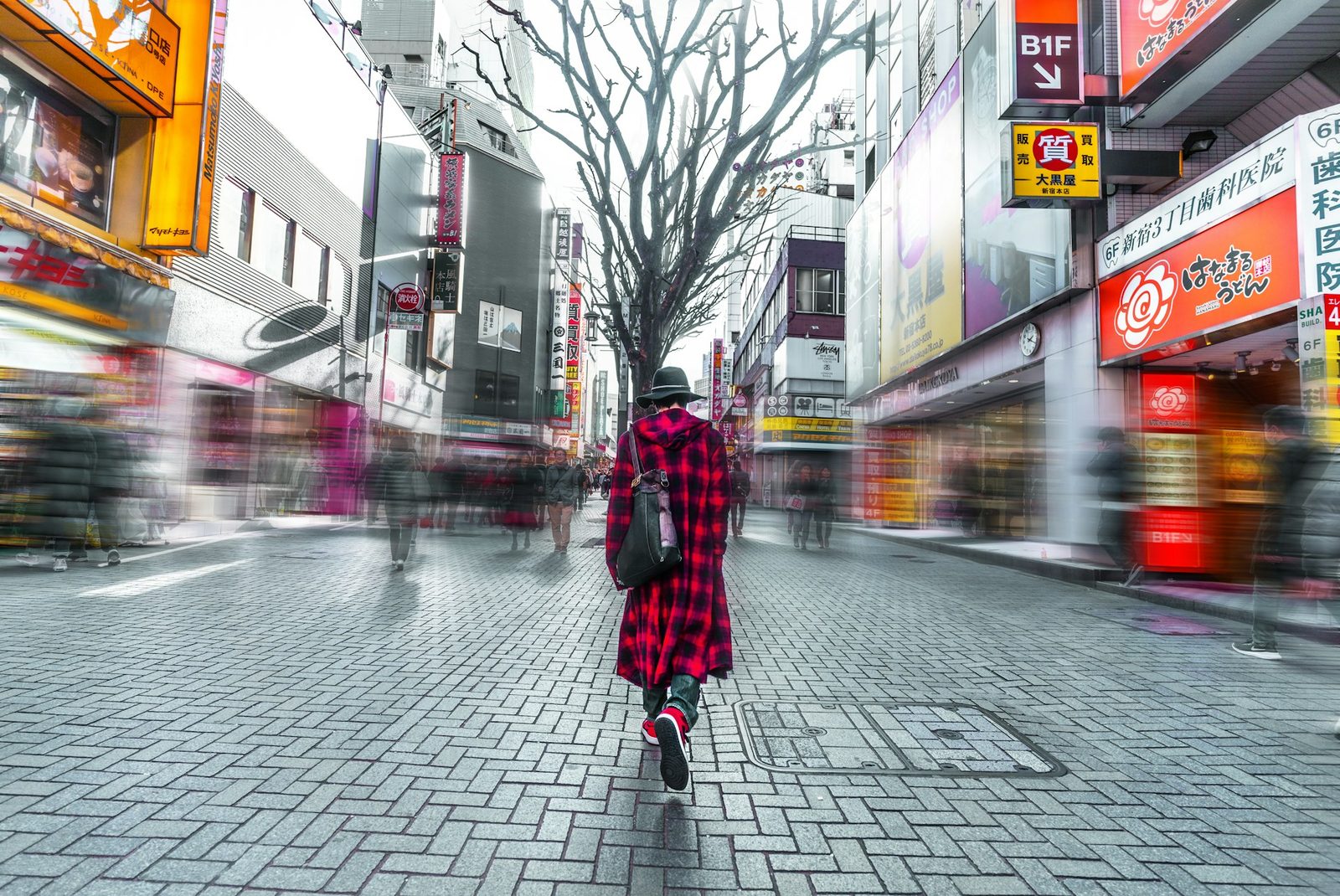 Solo female traveler walking through a busy Tokyo shopping street