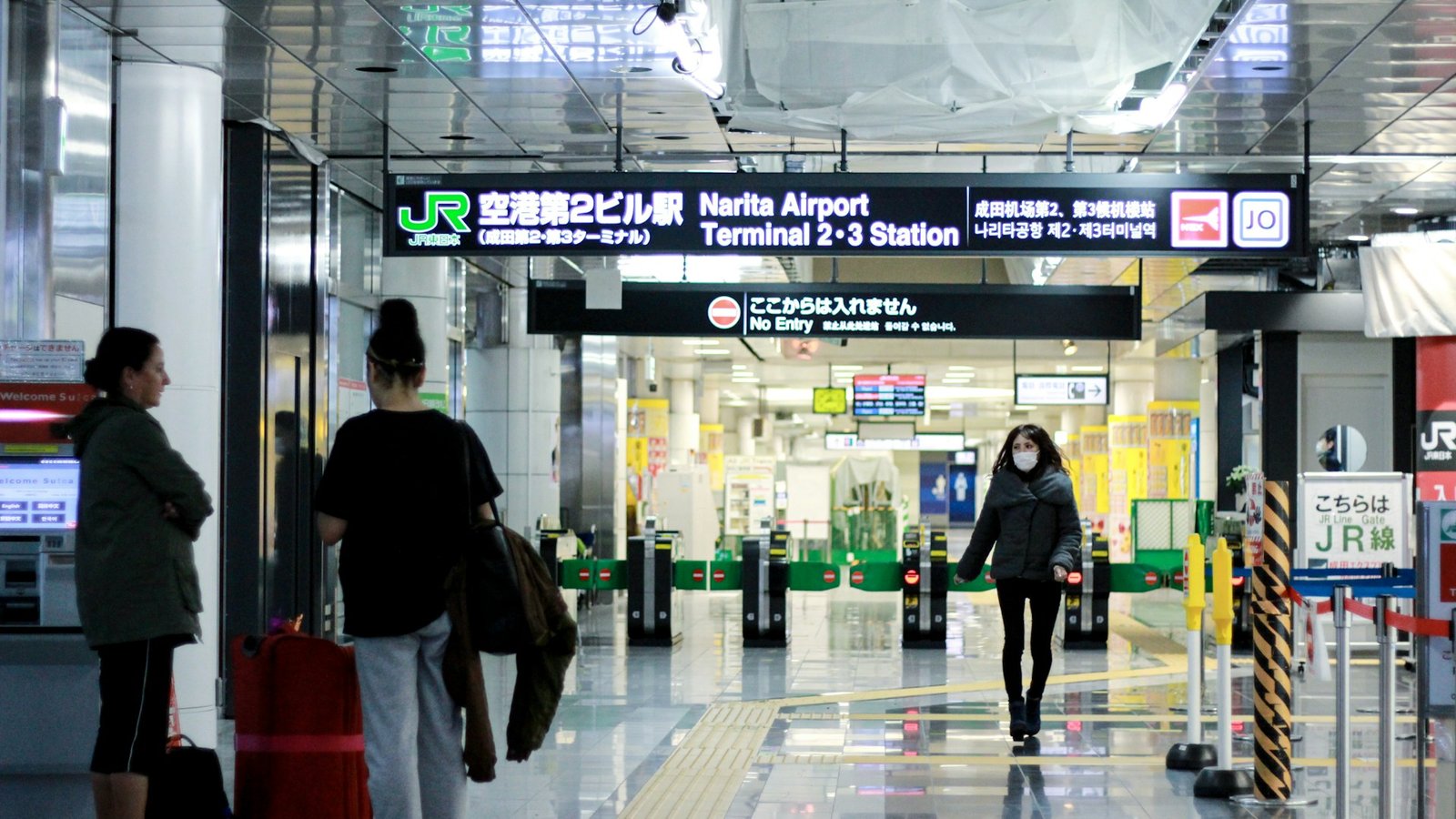 Travelers with suitcases at Narita Airport Terminal 2-3 JR station in Japan
